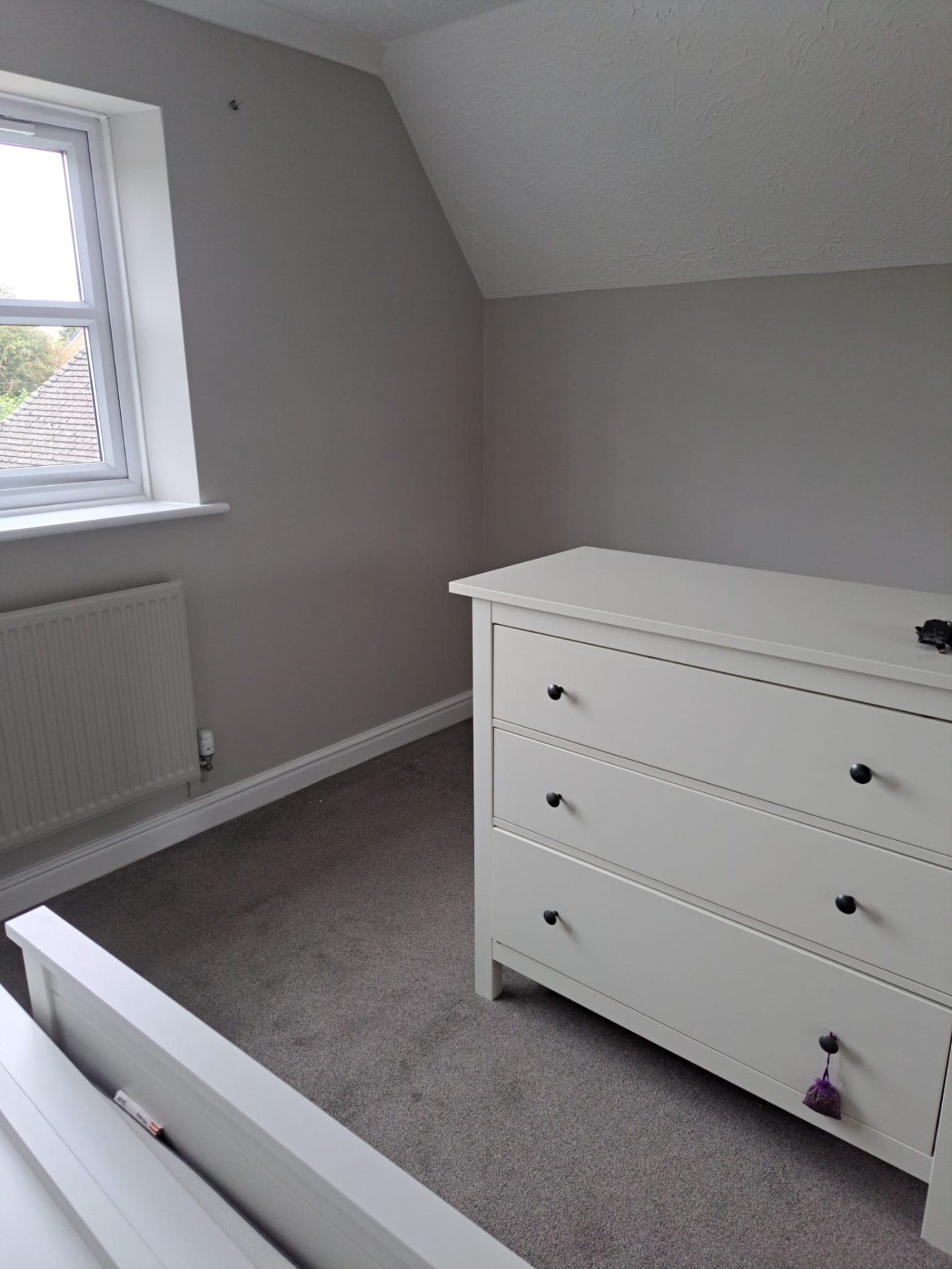 Bedroom decorated in soft grey with crisp white ceilings and woodwork