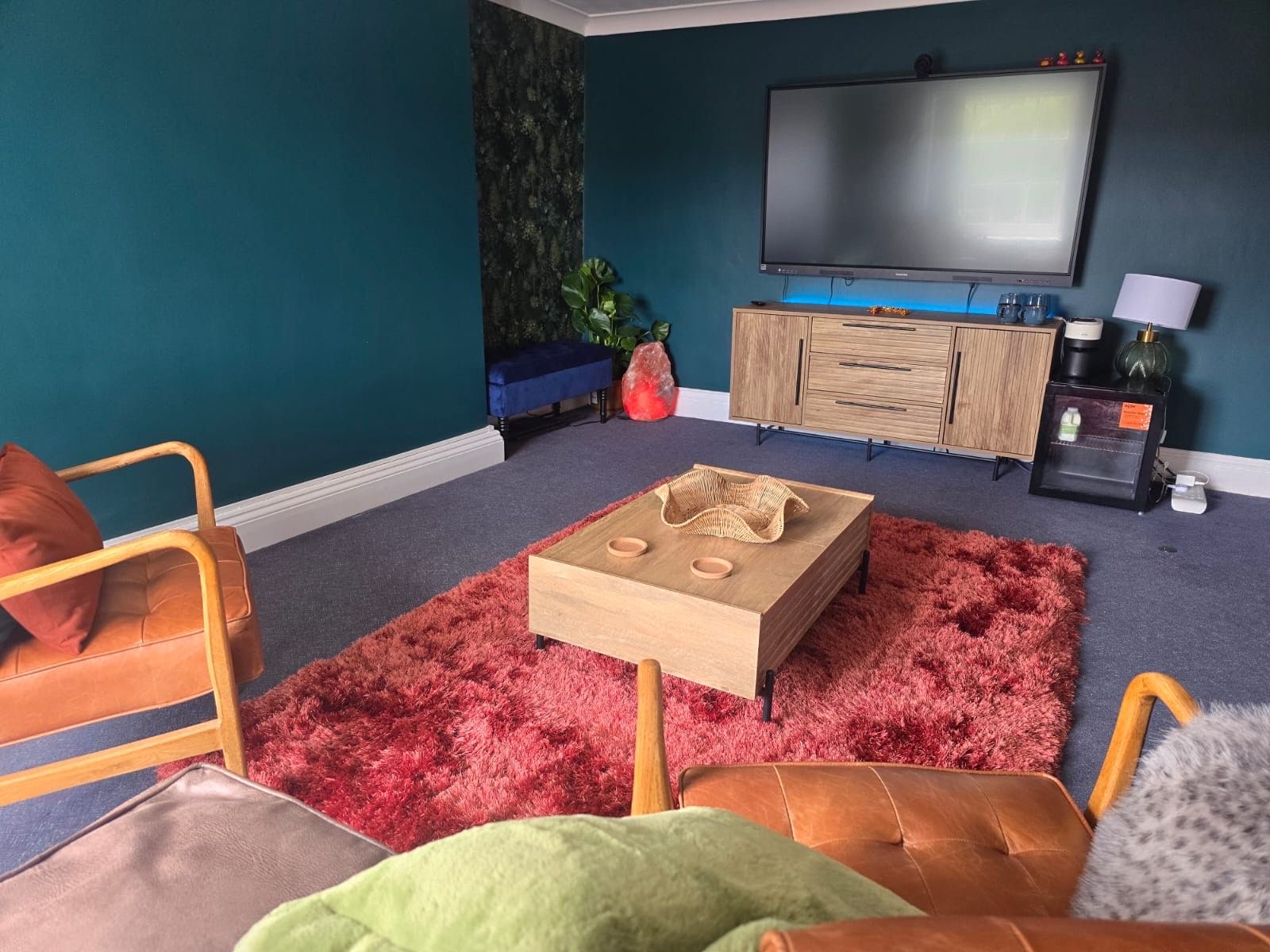 Living room redecorated with deep teal feature walls and new flooring